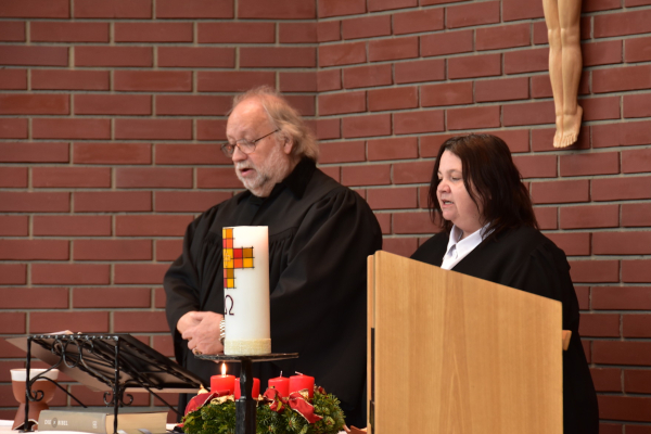 Lektor Ronald Schulz und Lektorin Claudia Buchner stehen hinter dem Altar